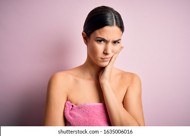 Young beautiful girl wearing towel shower after bath standing over isolated pink background thinking looking tired and bored with depression problems with crossed arms. - Shutterstock ID 1635006016