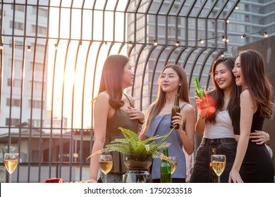 Young Beautiful Group Of Asian Girl Frinds Holding Beer Bottle Chatting And Smiling Together In Party At Rooftop On Evening With Lens Flare And Copy Space