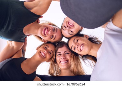 Young beautiful group of sportwomen smiling happy. Standing hugging with smile on face at gym