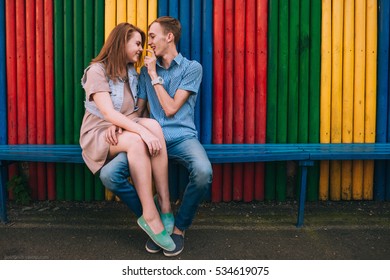 young and beautiful guy and girl sitting together on the bench