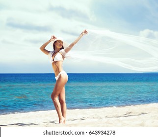 Young and beautiful, happy woman having a good time on a summer beach. Travel, resort, vacation, concept.
