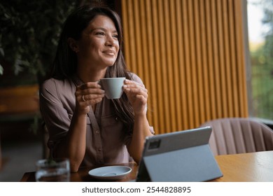 Young beautiful happy woman with long curly hair enjoying cappuccino in a street cafe - Powered by Shutterstock