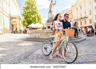 Young Beautiful Hipster Couple In Love Walking With Bicycle On Old City Street, Summer Europe Vacation, Travel, Fun, Happy, Smiling, Sunglasses, Trendy Outfit, Romance, Date