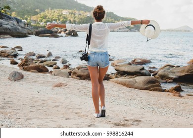 Young Beautiful Hipster Woman On Summer Vacation In Asia, Relaxing On Tropical Beach, Digital Photo Camera, Casual Boho Style, Sea Landscape Background, Slim Tanned Body, Travel Alone, Freedom
