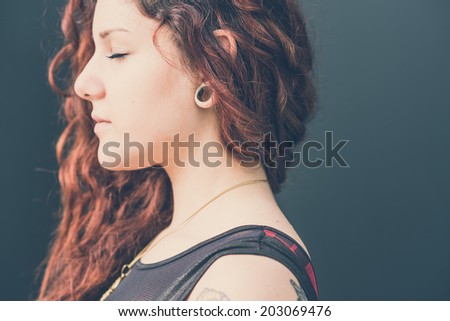 young beautiful hipster woman with red curly hair in the city