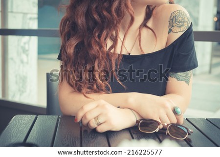 young beautiful hipster woman with red curly hair at the bar