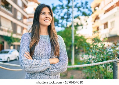 Young beautiful hispanic girl smiling happy and with crossed arms standing at the city.