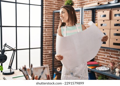 Young beautiful hispanic woman artist smiling confident holding draw at art studio - Powered by Shutterstock