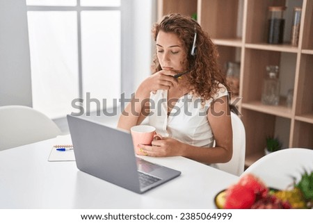 Young beautiful hispanic woman call center agent stressed working at home