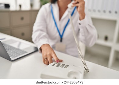 Young beautiful hispanic woman doctor using laptop talking on telephone at clinic - Powered by Shutterstock