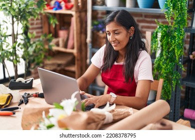 Young beautiful hispanic woman florist smiling confident using laptop at flower shop - Shutterstock ID 2208378795
