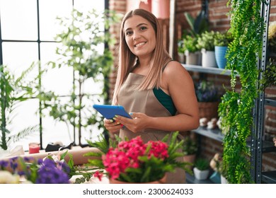 Young beautiful hispanic woman florist smiling confident using touchpad at florist - Powered by Shutterstock