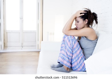 Young Beautiful Hispanic Woman In Painful Expression Suffering Menstrual Period Pain Lying Sad On Home Sofa Couch Having Tummy Cramp In Female Health Concept