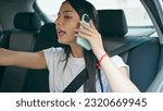 Young beautiful hispanic woman passenger talking on smartphone telling destination to taxi driver at street