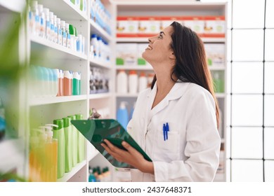 Young beautiful hispanic woman pharmacist writing on document at pharmacy - Powered by Shutterstock