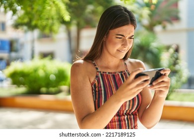 Young Beautiful Hispanic Woman Playing Video Game At Park