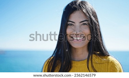 Young beautiful hispanic woman smiling confident standing at seaside