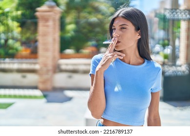 Young Beautiful Hispanic Woman Smoking At Street