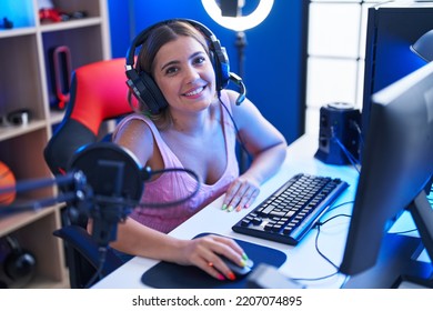 Young Beautiful Hispanic Woman Streamer Playing Video Game Using Computer At Gaming Room