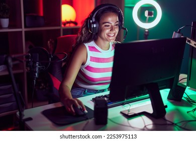 Young beautiful hispanic woman streamer playing video game using computer at gaming room - Powered by Shutterstock