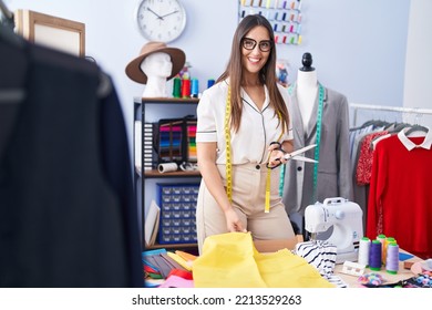 Young beautiful hispanic woman tailor smiling confident cutting cloth at clothing factory - Powered by Shutterstock