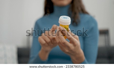 Young beautiful hispanic woman taking pills at home