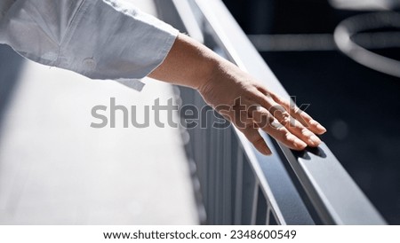 Young beautiful hispanic woman touching balustrade with hand in the streets of Madrid