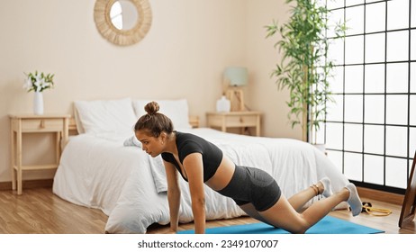 Young beautiful hispanic woman training push up at bedroom - Powered by Shutterstock