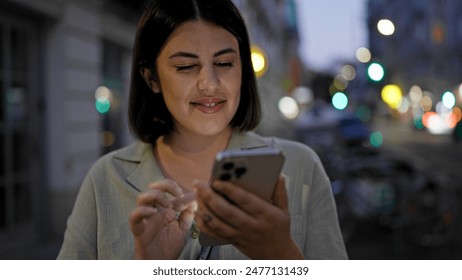 Young beautiful hispanic woman using smartphone in the streets at night - Powered by Shutterstock