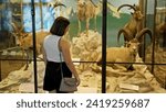 Young beautiful hispanic woman visiting natural history exhibition at Natural History Museum in Vienna