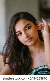 A Young And Beautiful Indian Asian Woman Sits For Her Portrait Head Shot In A Stylish Cafe During The Day. She Projects Confidence And She Looks Like She Belongs In High Society. 