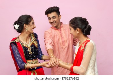 Young Beautiful Indian Brother Sister celebrating Rakshabandhan or Bhai dooj tying Rakhi, Showing money, laughing cheering, Enjoying and eating sweets.Selective Focus (Rakshabandhan/Bhai dooj Concept)