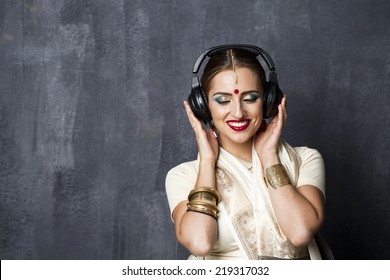 Young Beautiful Indian Woman Listening To Music On Headphones