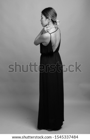 Similar – beautiful brunette short hair girl leaning against  gray rock wall outdoors, wearing black clothes