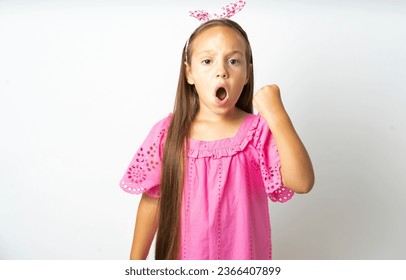 Young beautiful kid girl wearing pink dress angry and mad raising fist frustrated and furious while shouting with anger. Rage and aggressive concept. - Shutterstock ID 2366407899