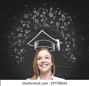 Young beautiful lady is thinking about studying at the university. Educational icons are drawn on the black chalk board. - Powered by Shutterstock