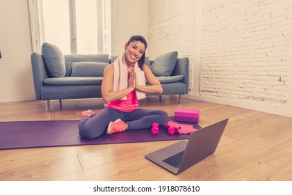 Young beautiful latin woman working out at home connected to online fitness class on the computer laptop. Woman personal trainer coach on zoom teaching exercises in live streaming workout class. - Shutterstock ID 1918078610