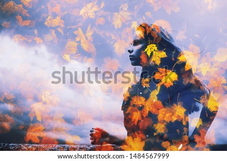 Young beautiful millenial girl in water reflection on falling leaves clouds background. Double or multiple exposure Autumn season, bad weather concept Abstract woman portrait, fall nature environment