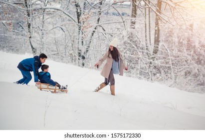 Young, Beautiful Mom And Her Cute Little Boy Enyoing Winter, Sledding