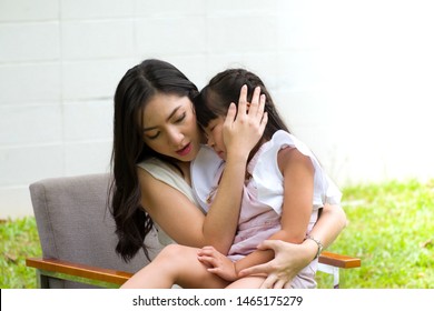 Young Beautiful Mom Hugging And Comforting Daughter From Falling Run And Cry Inside The Front Yard. Asian Mothers Showing Their Protection. Concepts Of Protecting The Kid.