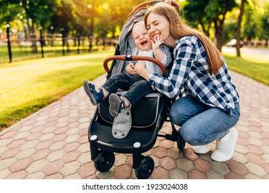 Young beautiful mother, with her little cute child, walking in the park on a sunny summer day. - Shutterstock ID 1923024038