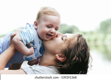 Young beautiful mother holding cute little baby boy smiling