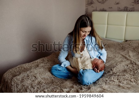 Similar – Mother giving bottle to her newborn