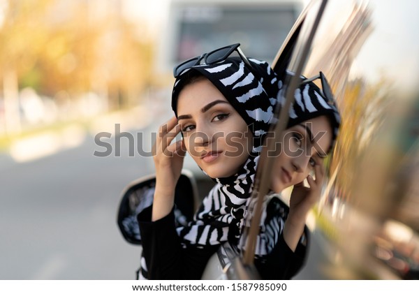 young beautiful\
muslim woman drives a car