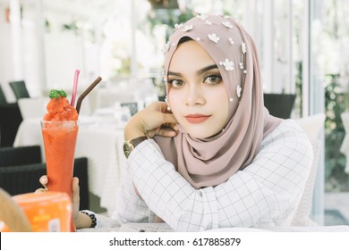 young beautiful muslim woman with the Strawberry smoothie  in restaurant. - Powered by Shutterstock