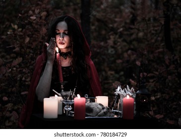 Young Beautiful And Mysterious Witch Woman Provide Dark Ritual In Woods With Detached Heart And Candles