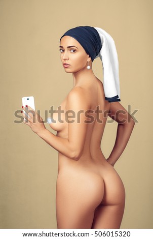 Young Beautiful Naked Woman With A Pearl Earring Is Holding A Phone And Makes Selfie Young Beautiful Naked Woman With A Pearl Earring Is Holding A Phone And Makes Selfie