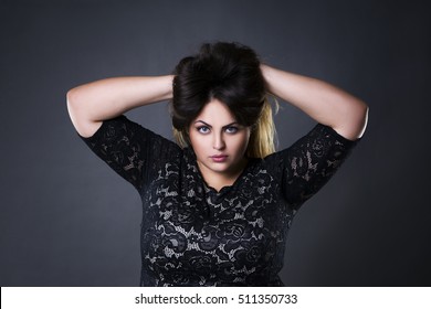 Young beautiful plus size model in black lace dres, xxl woman portrait on gray studio staras's