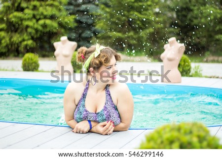 Young beautiful plus size model splashing in the pool, xxl woman portrait, professional makeup and hairstyle