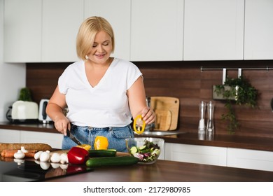 Young Beautiful Plus Size Plump Caucasian Woman Housewife Cooking Healthy Food, Making Vegetable Salad, Cutting For Preparing Vegetarian Vegan Meal At Home Kitchen